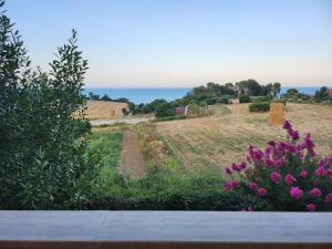 a view of a field with flowers and the ocean at The Blue Room in Porto SantʼElpidio