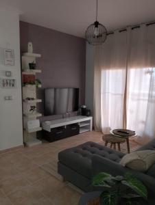sala de estar con sofá y TV de pantalla plana en Apartamento Serena beach, en Águilas