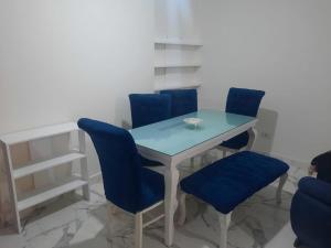 ein Esszimmer mit blauen Stühlen und einem Tisch in der Unterkunft Nice Apartment next to the Sea in Miami Alexandria in Alexandria