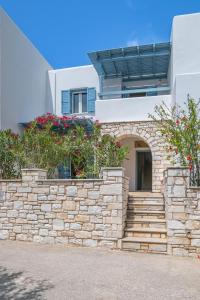 a stone retaining wall with stairs in front of a building at Aliki Maisonette by the beach in Aliki