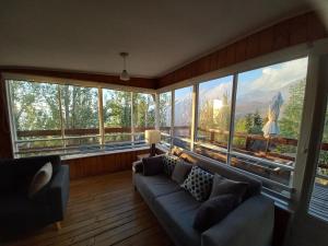 a living room with a couch and large windows at Lodge Andes in Farellones