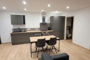 une cuisine avec une table et des chaises dans une pièce dans l'établissement Superbe appartement T2 climatisé, idéalement situé, à Ugine 3 autres photos