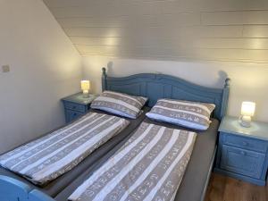 2 camas individuales en una habitación con armarios azules en Apartment Alter Bahnhof by Interhome en Neugarmssiel