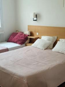 a bedroom with two beds and a wooden headboard at Tour de la chaine, vieux port, Grand Appartement in La Rochelle