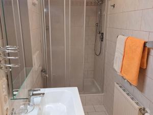 uma casa de banho com um chuveiro e um lavatório branco em Apartment Waldfrieden by Interhome em Oberwang