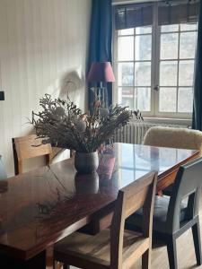 a dining room table with a vase of flowers on it at Tour de la chaine, vieux port, Grand Appartement in La Rochelle