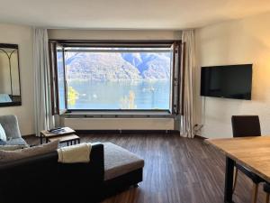 a living room with a large window with a view of a lake at Apartment Suite Classic-15 by Interhome in Ascona