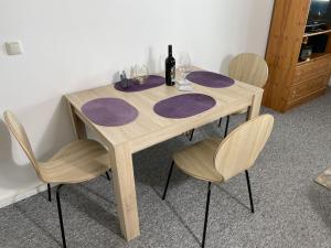 una mesa de madera con 3 sillas y una botella de vino en Apartment Blaumuschel - LUB113 by Interhome, en Lubmin