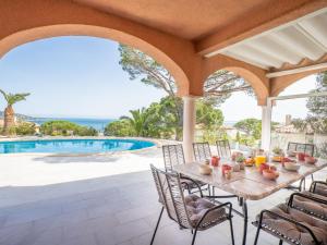 un patio avec une table et des chaises à côté d'une piscine dans l'établissement Villa Cacharel - MAX230 by Interhome, à Sainte-Maxime