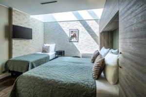 una camera d'albergo con due letti e una televisione di Hotel Atlantis Amsterdam ad Amsterdam
