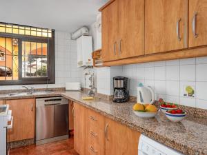 una cocina con armarios de madera y cuencos de fruta en la encimera en Apartment Dona Lola by Interhome, en Sitio de Calahonda