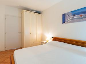 sypialnia z białym łóżkiem i szafką w obiekcie Apartment Belvedere by Interhome w mieście Bellano