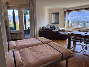 un soggiorno con 2 letti e un divano di Apartment Suite Classic-16 by Interhome ad Ascona