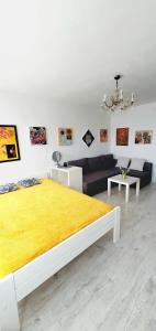 ワルシャワにあるワルシャワ ツェントラム アパルタメント ダニエラのベッドルーム1室(大型ベッド1台、黄色い毛布付)
