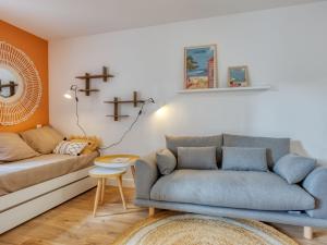 ein Wohnzimmer mit einem Sofa und einem Tisch in der Unterkunft Apartment Village Cheval Spa Résidences-1 by Interhome in Lacanau-Océan