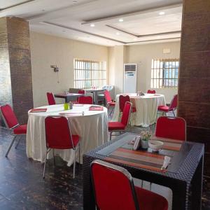 uma sala com mesas e cadeiras vermelhas e mesa de procura em HOTEL MAVILLA Cotonou em Cotonou