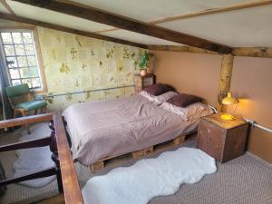 a bedroom with a bed and a table and a window at The Summerhouse in Llandegla