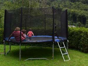 una mujer y dos niños jugando en un trampolín en Apartment Barmettlenstrasse 26 by Interhome, en Engelberg