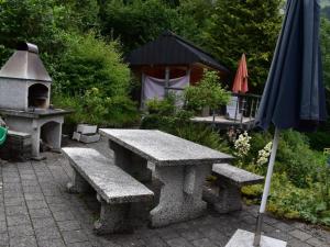 uma mesa de piquenique e um grelhador com um guarda-chuva em Apartment Barmettlenstrasse 26 by Interhome em Engelberg