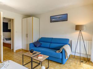 a living room with a blue couch and a table at Studio Le Béniguet by Interhome in Légenès +17 photos