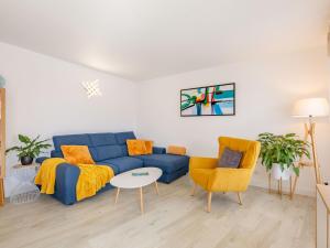 a living room with a blue couch and two chairs at Apartment Royal Marine-2 by Interhome in Fréjus