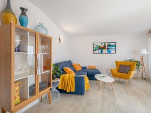 sala de estar con sofá azul y sillas amarillas en Apartment Royal Marine-2 by Interhome en Fréjus