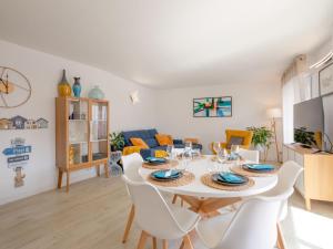 a dining room and living room with a table and chairs at Apartment Royal Marine-2 by Interhome in Fréjus +17 photos