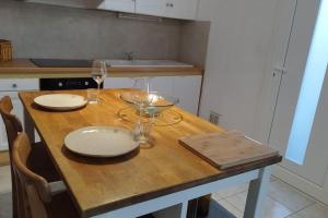 una mesa de madera con dos vasos y un tazón. en Charmante Maison T2 de plein pied avec extérieur calme aux Arènes, en Béziers