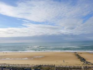 - une plage avec des gens sur le sable et l'océan dans l'établissement Apartment Primavéra-8 by Interhome, à Lacanau-Océan