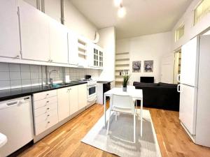 a white kitchen with a table and a white refrigerator at Stor lägenhet på Vasagatan in Gothenburg