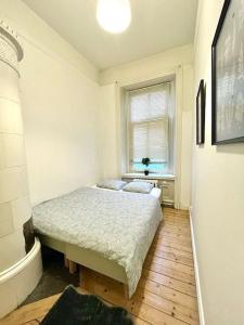 a small bedroom with a bed and a window at Stor lägenhet på Vasagatan in Gothenburg