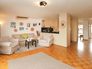 uma sala de estar com dois sofás brancos e uma mesa em Apartment Vasco de Gama B11-R by Interhome em Bouveret