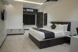 a bedroom with a large bed and a television at Goldeye's Inn in Erode