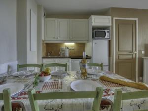 une cuisine avec une table avec deux chaises et une table sidx sidx sidx dans l'établissement Apartment Les Rivages de Coudoulière-9 by Interhome, à Six-Fours-les-Plages