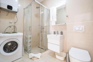 uma casa de banho com uma máquina de lavar roupa e um chuveiro em Mariner Apartments em Sutomore