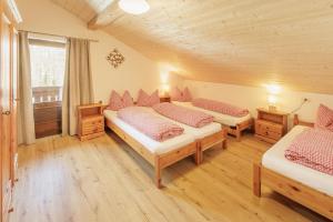 a bedroom with three beds in a room with a window at Wohnung in Mühlwald mit Grill und Garten in Lappago