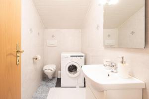 a bathroom with a washing machine and a sink at Wohnung in Mühlwald mit Grill und Garten in Lappago