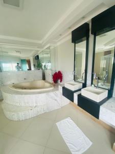 a large bathroom with two sinks and two mirrors at SHELTON PALACE HOTEL in Paranavaí
