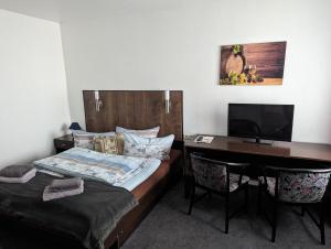 a bedroom with a bed and a desk with a computer at Gasthaus alt Freyburg in Freyburg