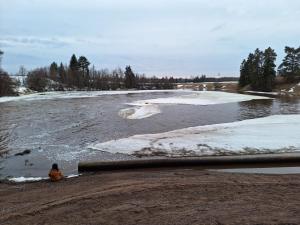 Charming Studio-Perfect Getaway في Nummistenkylä: شخص جالس بجانب نهر فيه ثلج