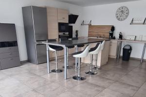 una cucina con tavolo, sedie e orologio di super appartement 100m2 a Ribeauvillé