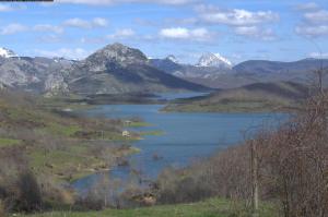 vistas a un lago con montañas en el fondo en El Urogallo de Rucayo en Boñar