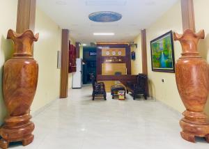 un corridoio con due grandi vasi in legno sul pavimento di HOTEL HOÀNG LONG a Dien Bien Phu