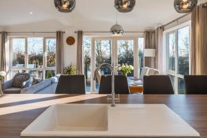 een keuken en een woonkamer met een wastafel en een tafel bij Luxurious 2-Bed Lodge in St Helens Ryde in Saint Helens