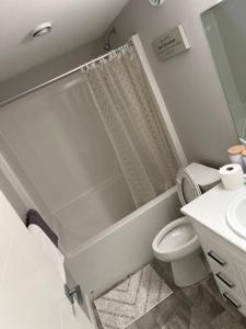 a bathroom with a shower and a toilet and a sink at Private Basement Suite with comfort in Winnipeg