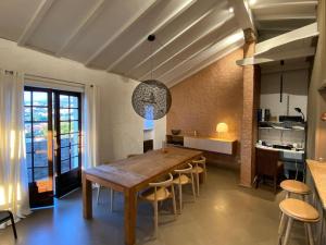 a kitchen and dining room with a wooden table and chairs at Maison Conviviale, Vue Mer in Propriano