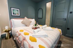 una camera da letto con un letto, asciugamani e bottiglie di champagne di BRAND NEW light & airy 1 bed, Bmth centre, beaches - Hip Nautic a Bournemouth