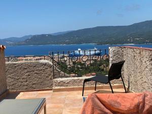 a chair sitting on a balcony with a view of the water at Maison Conviviale, Vue Mer in Propriano