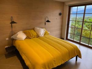 a bedroom with a bed with yellow sheets and two lamps at Maison Conviviale, Vue Mer in Propriano
