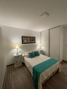 1 dormitorio con 1 cama con 2 mesitas de noche y 2 lámparas en Hermoso departamento funcional Torre Pacha en Santiago del Estero